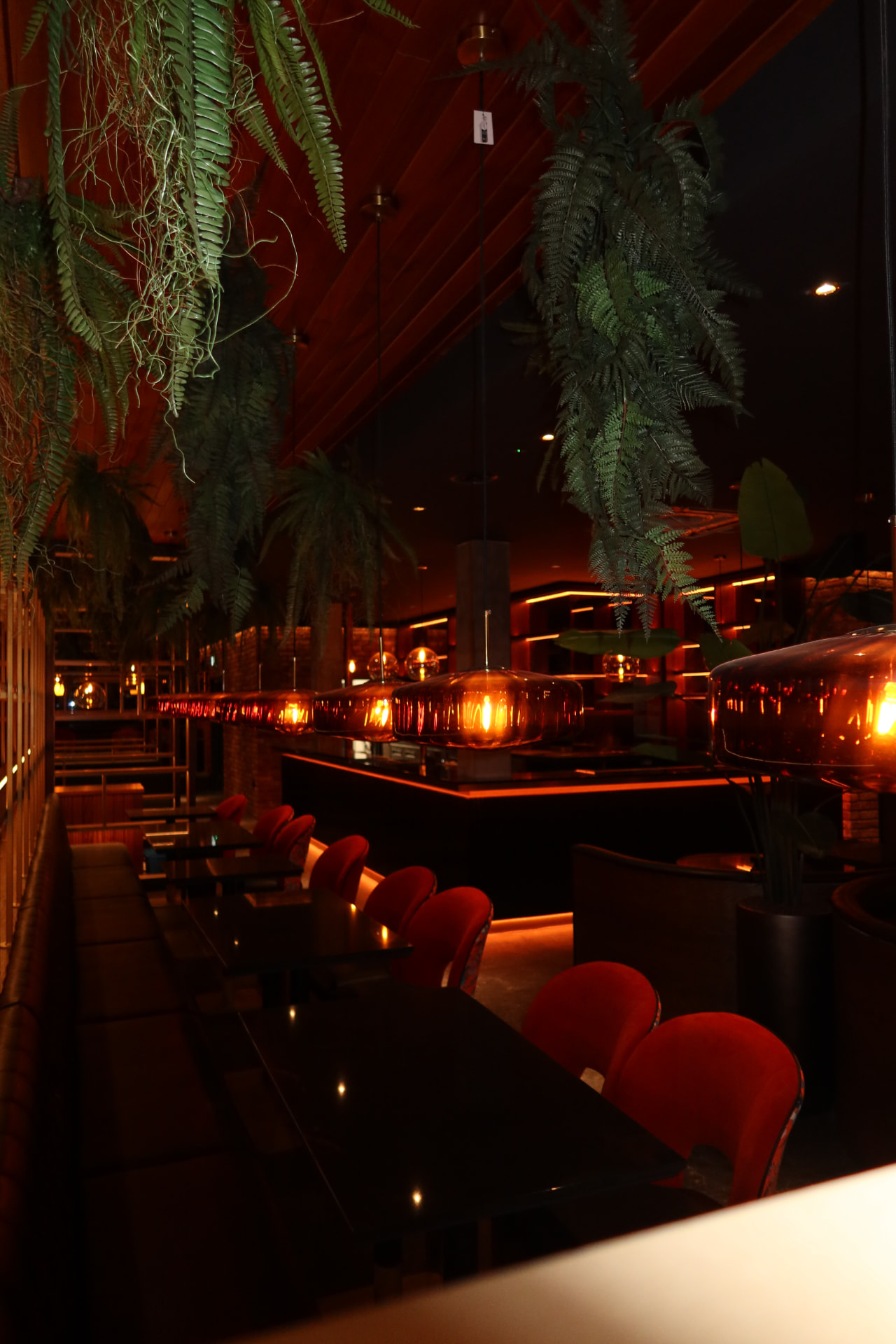 Red velvet seating and amber glass pendants in the cocktail lounge