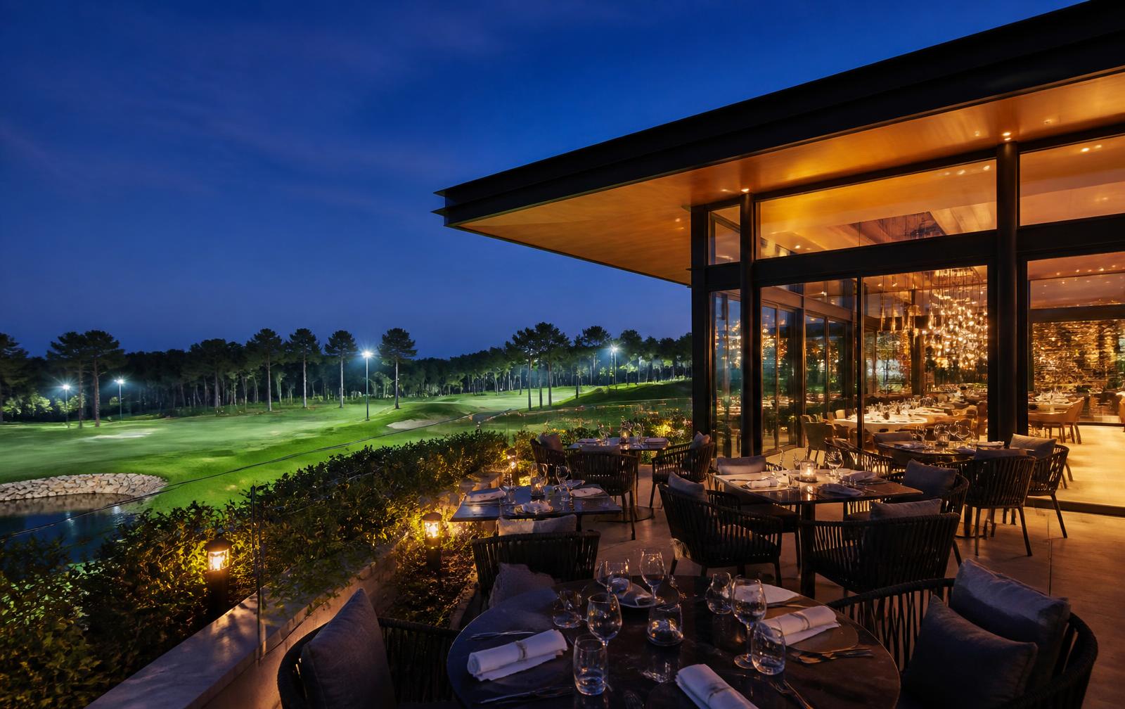Terrace dining overlooking the floodlit golf course at Marton at dusk